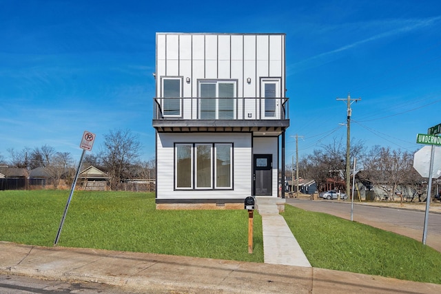 modern home with a balcony and a front yard