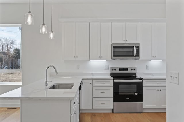 kitchen with white cabinetry, sink, decorative light fixtures, and appliances with stainless steel finishes