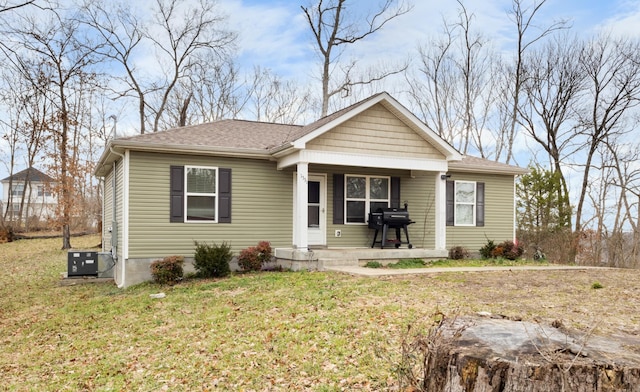 bungalow with central AC, a porch, and a front yard