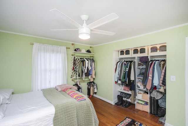 bedroom featuring crown molding, dark wood-type flooring, ceiling fan, and a closet