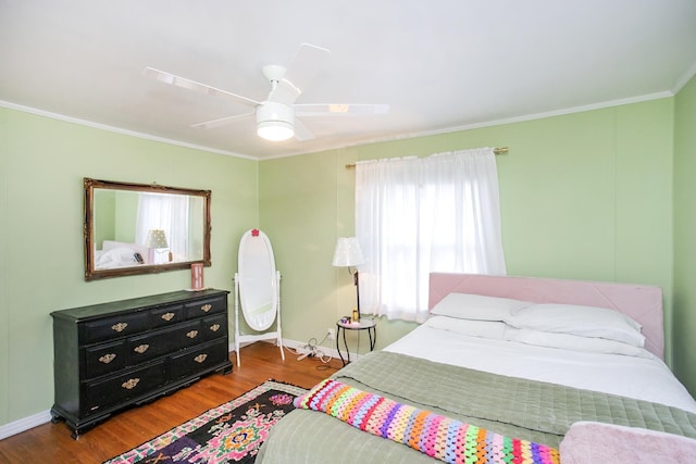 bedroom with ornamental molding, dark hardwood / wood-style floors, and ceiling fan