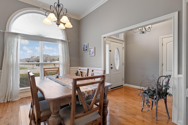 dining space featuring crown molding, light hardwood / wood-style floors, and a chandelier