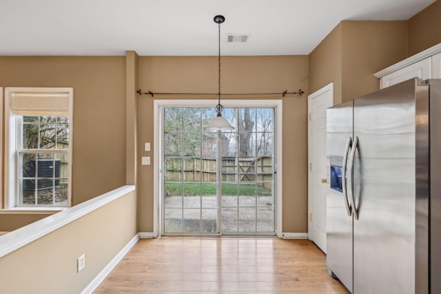 unfurnished dining area with plenty of natural light and light hardwood / wood-style floors