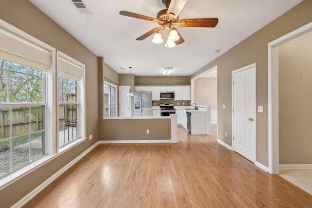 unfurnished living room with ceiling fan, sink, and light hardwood / wood-style floors