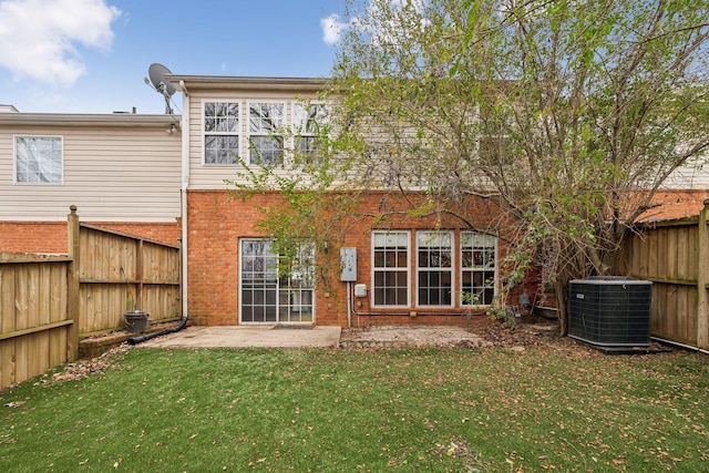 rear view of property featuring a yard, central AC, and a patio