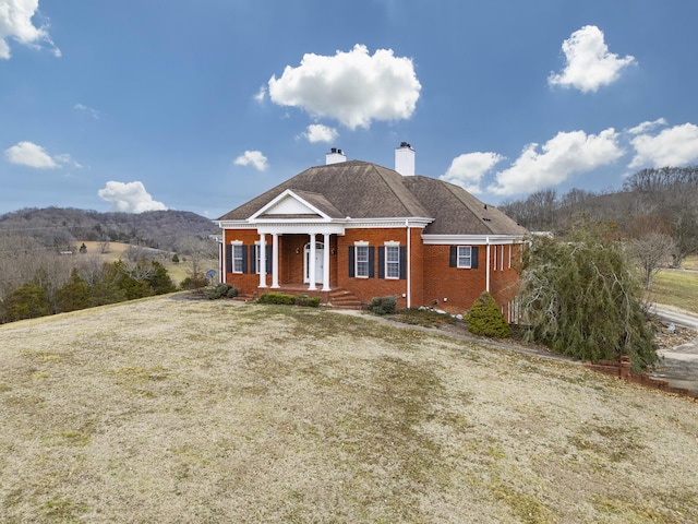 view of front of property with a mountain view and a front lawn