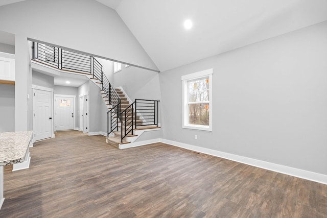 interior space with dark hardwood / wood-style flooring and high vaulted ceiling