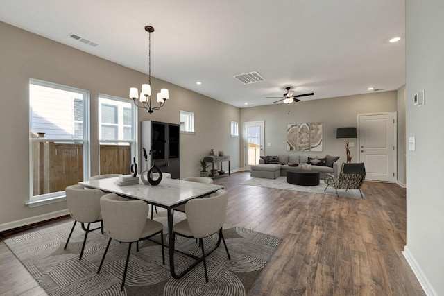 dining area featuring hardwood / wood-style floors and ceiling fan with notable chandelier