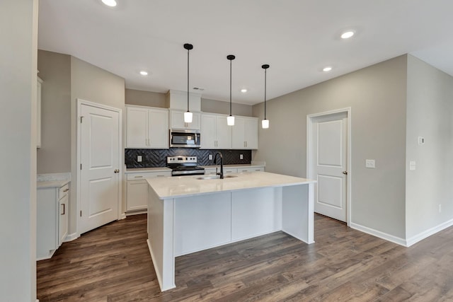 kitchen featuring a kitchen island with sink, sink, white cabinets, and appliances with stainless steel finishes