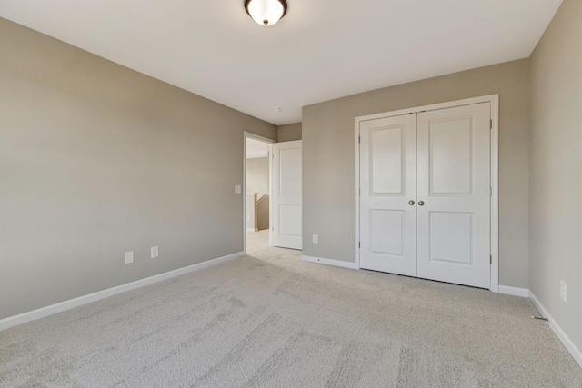 unfurnished bedroom featuring light carpet and a closet