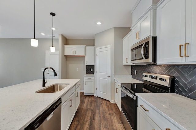 kitchen with appliances with stainless steel finishes, pendant lighting, sink, white cabinets, and light stone countertops