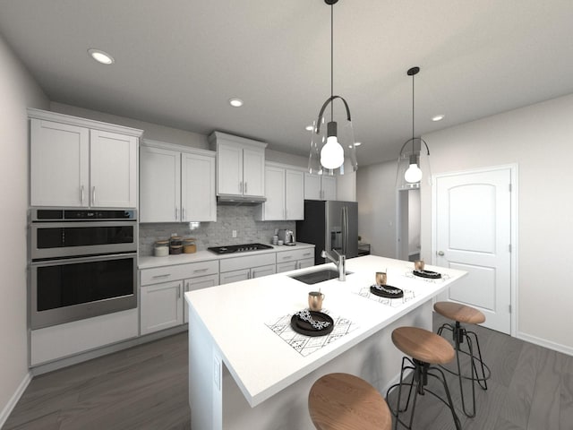 kitchen featuring sink, appliances with stainless steel finishes, an island with sink, white cabinets, and decorative light fixtures