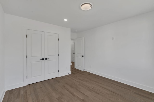 unfurnished bedroom with wood-type flooring and a closet