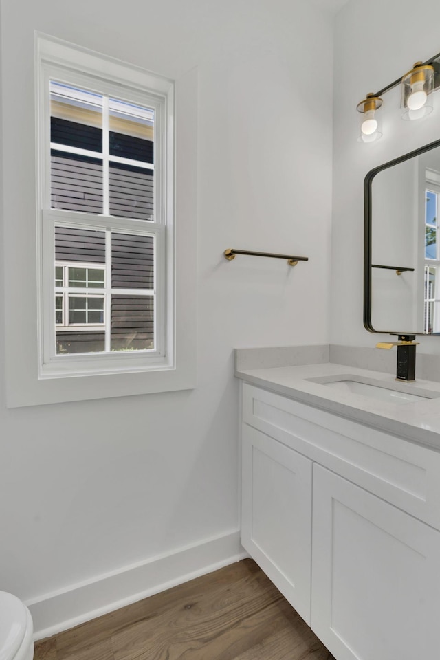 bathroom featuring vanity, hardwood / wood-style floors, and toilet