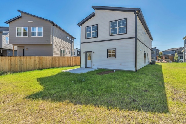 back of house with a patio area and a lawn