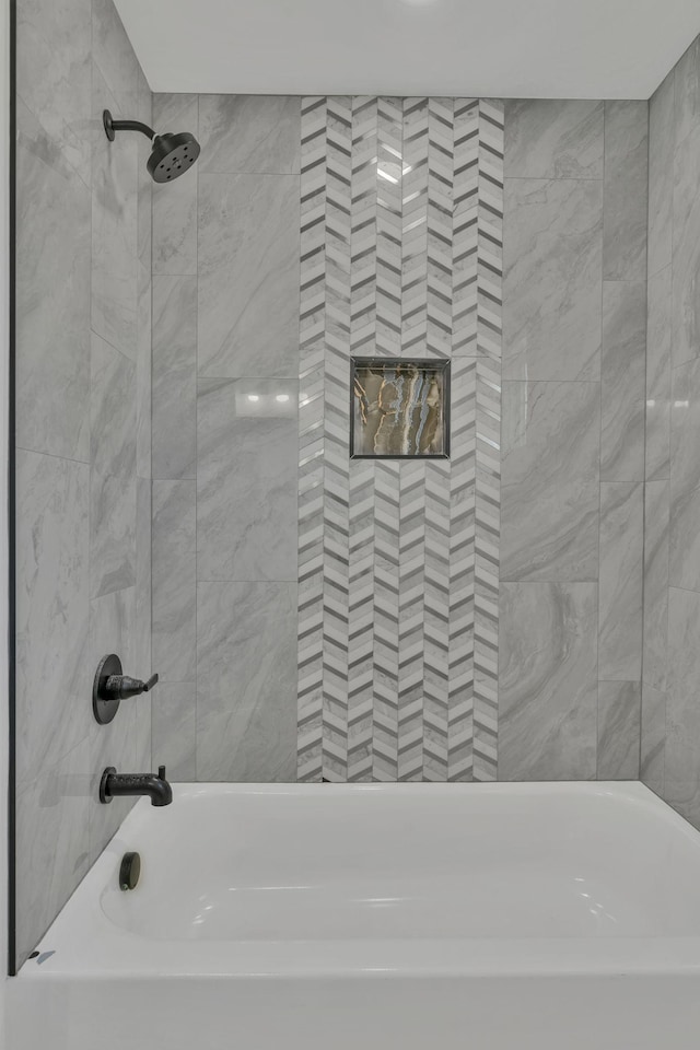 bathroom featuring tiled shower / bath