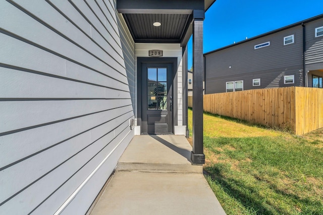 entrance to property featuring a lawn