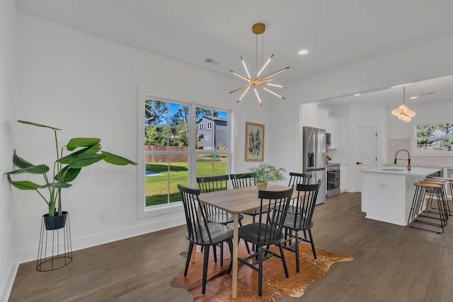 dining room featuring dark hardwood / wood-style flooring, a notable chandelier, and sink