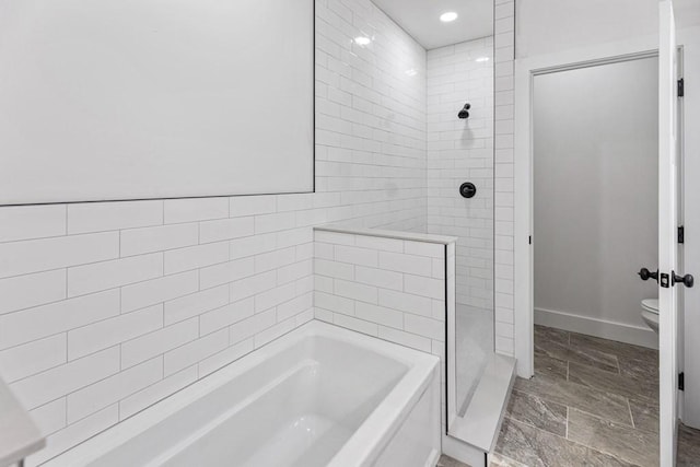 bathroom featuring toilet and separate shower and tub