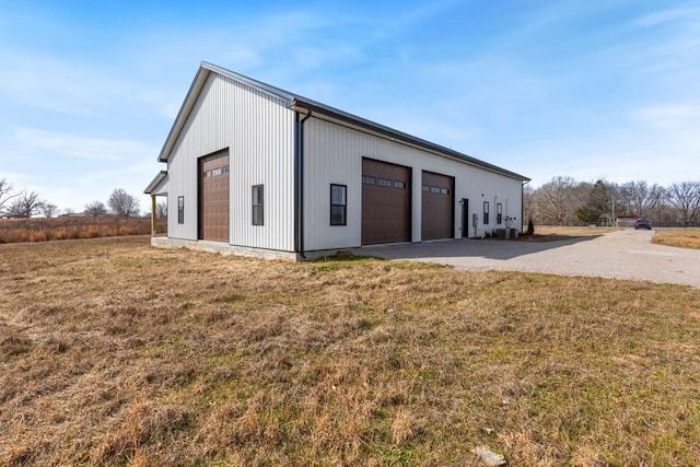 view of side of home featuring a garage, an outdoor structure, and a yard