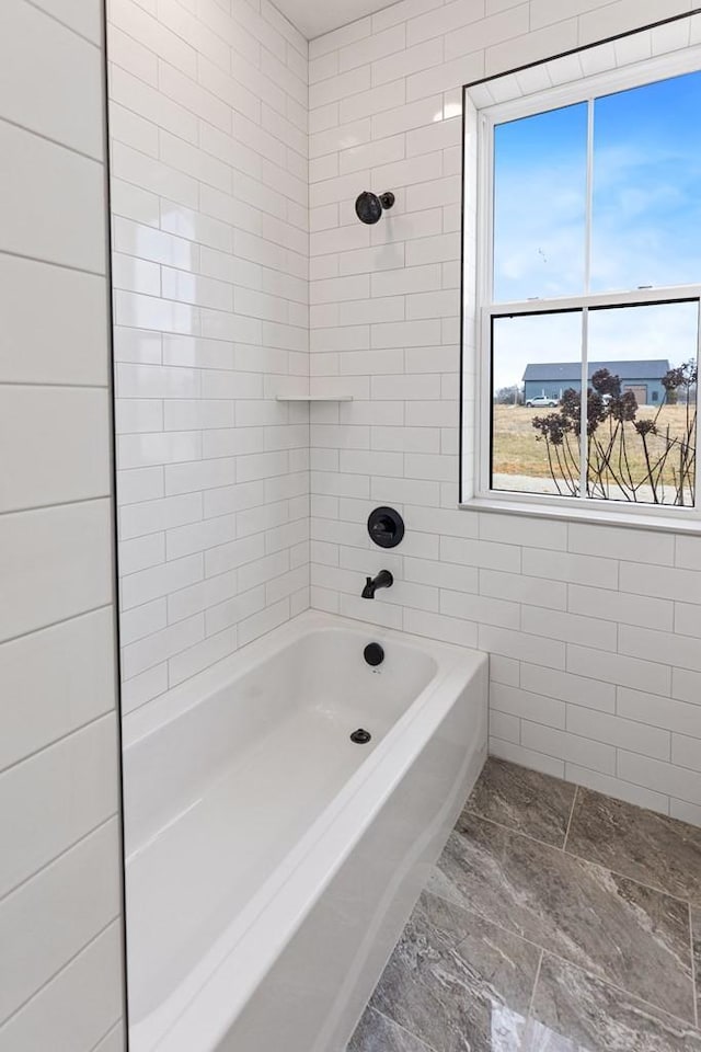bathroom with tiled shower / bath and tile walls