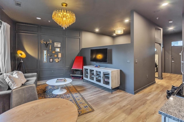 living room with a notable chandelier and light wood-type flooring