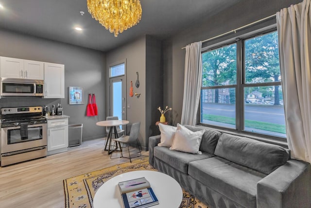 living room featuring an inviting chandelier and light hardwood / wood-style flooring