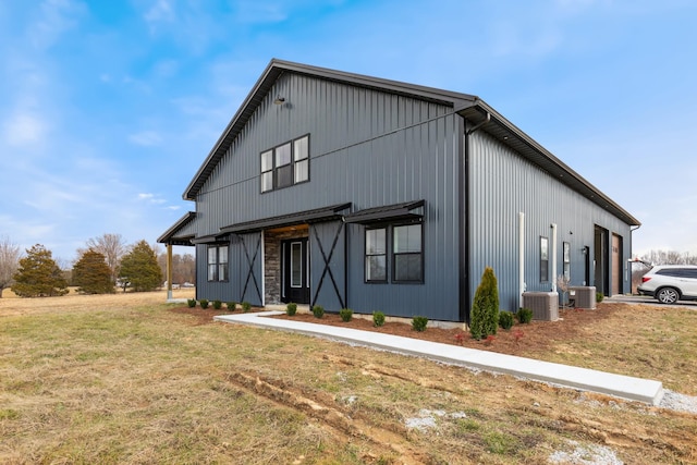 view of front of property featuring cooling unit and a front lawn