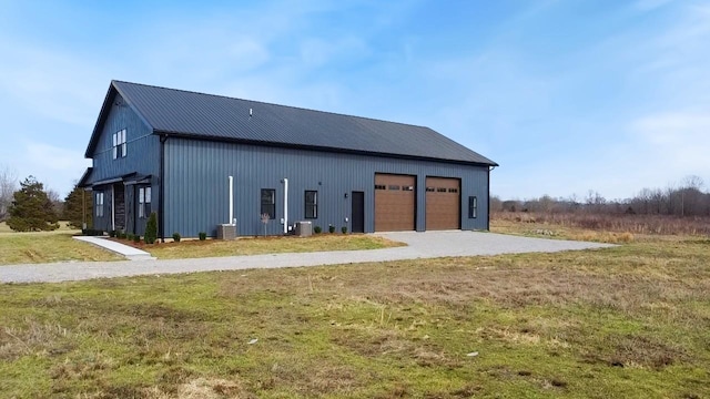 exterior space featuring a garage, a yard, and central AC