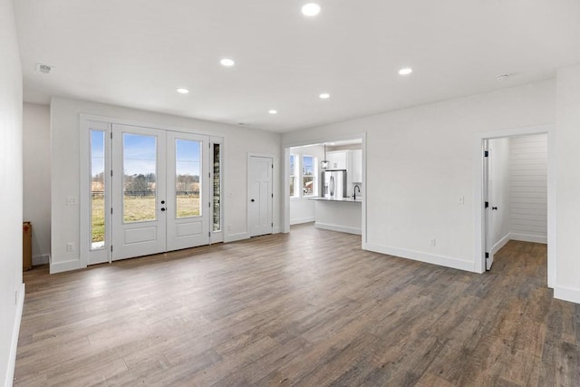 unfurnished room with sink, hardwood / wood-style floors, and french doors