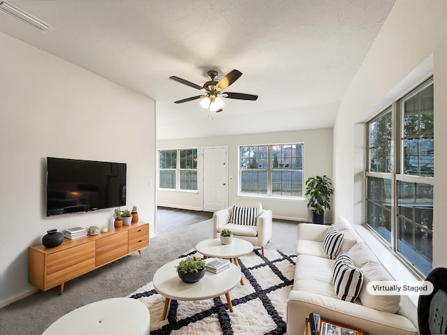 living room with ceiling fan and carpet