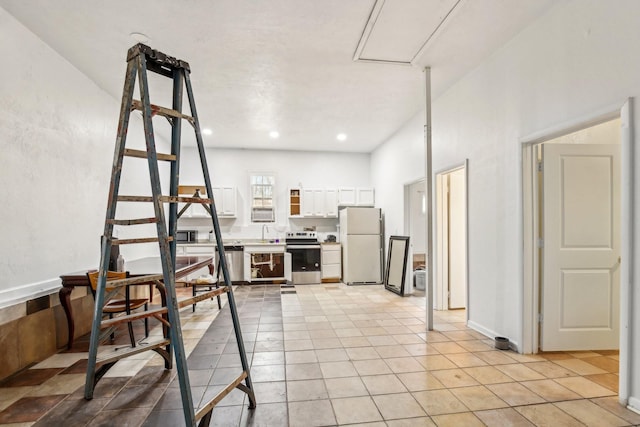 kitchen with sink, light tile patterned flooring, white cabinets, and appliances with stainless steel finishes