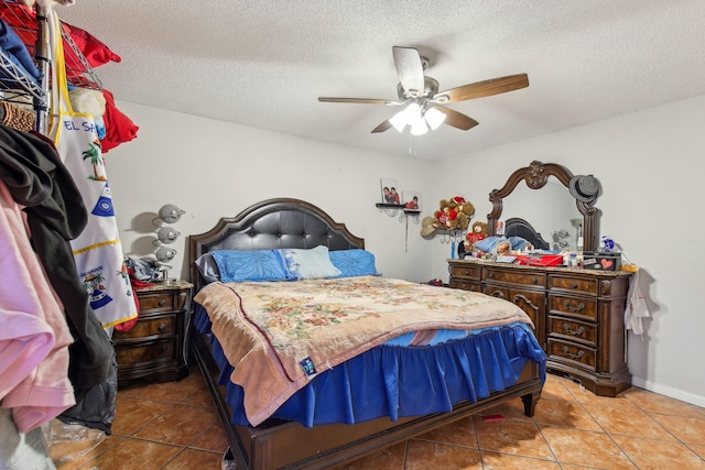 bedroom featuring light tile patterned flooring, ceiling fan, and a textured ceiling