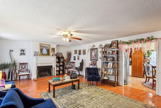 living room with light tile patterned floors, ornamental molding, a textured ceiling, and ceiling fan