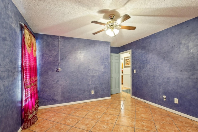 spare room with light tile patterned floors, a textured ceiling, and ceiling fan