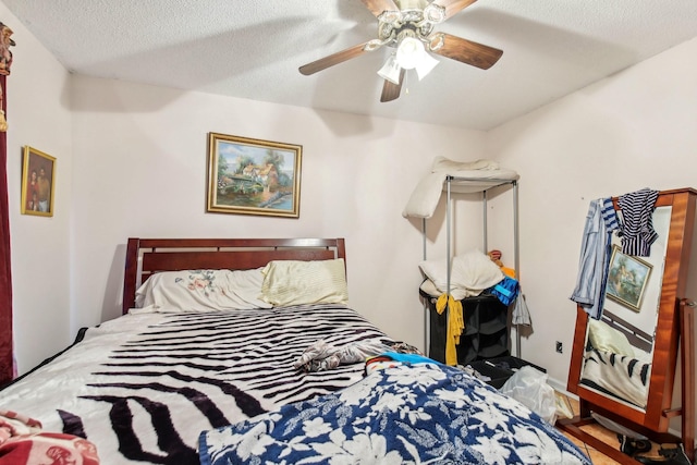 bedroom with ceiling fan and a textured ceiling