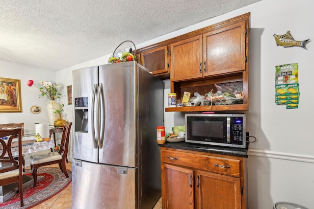 kitchen featuring light tile patterned floors, stainless steel appliances, and a textured ceiling