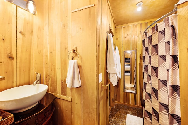 bathroom with sink and wood walls