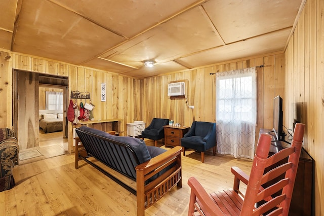 interior space with an AC wall unit, wooden walls, and light wood-type flooring