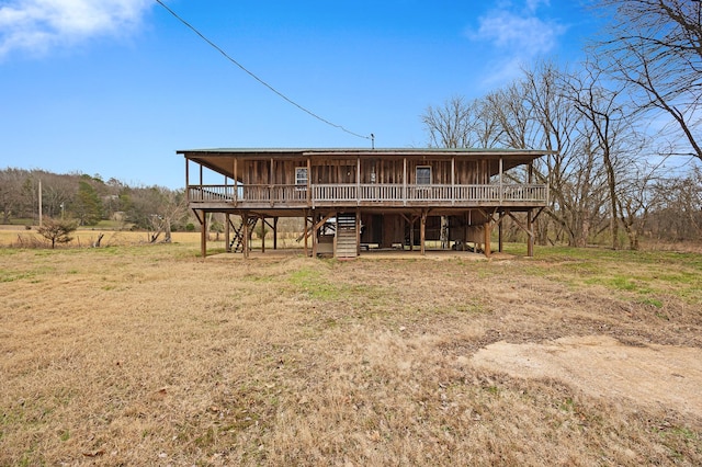 back of house with a rural view, a yard, and a deck