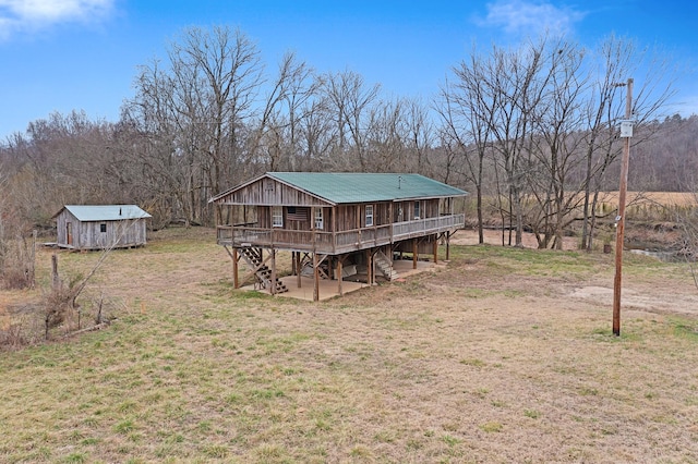 back of property with a wooden deck, a shed, and a lawn