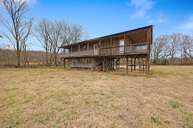 rear view of property featuring a wooden deck and a yard