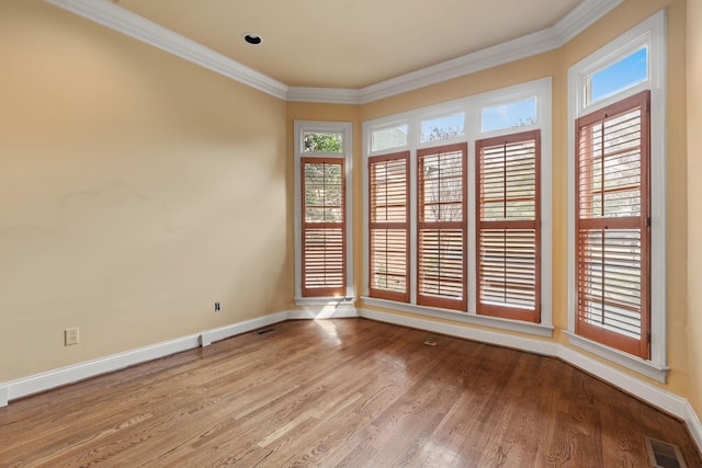 spare room featuring ornamental molding and light hardwood / wood-style floors