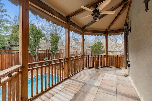 unfurnished sunroom with ceiling fan and vaulted ceiling with beams