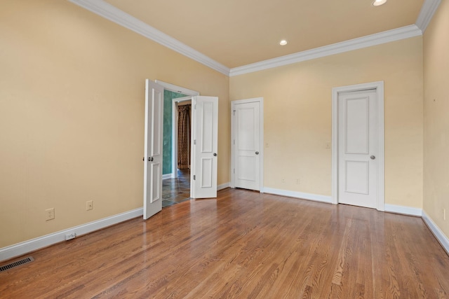 unfurnished bedroom featuring crown molding and hardwood / wood-style floors