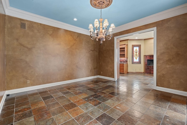 unfurnished room featuring crown molding, a tile fireplace, and a notable chandelier