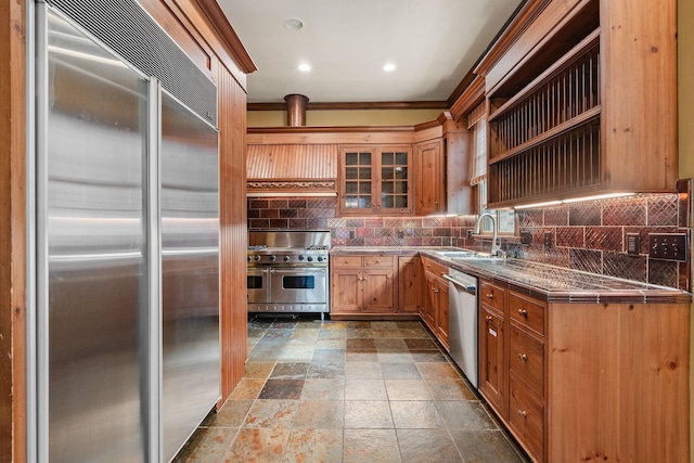 kitchen featuring high end appliances, backsplash, and sink