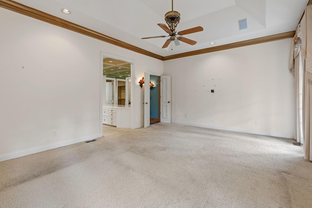 carpeted empty room with crown molding, ceiling fan, and a raised ceiling