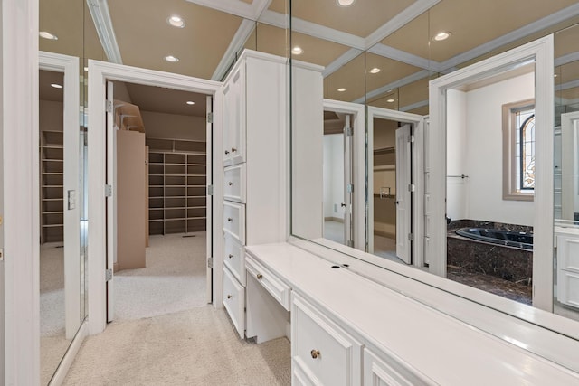 bathroom featuring ornamental molding and a tub to relax in