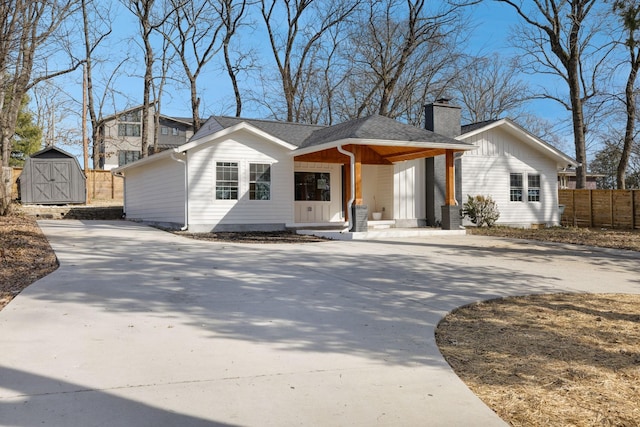 view of front of house featuring covered porch and a shed